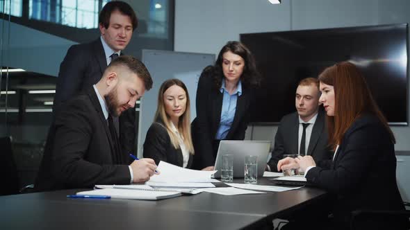 Business Partners Signing Contract and Shaking Hands alt