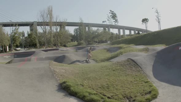 Cute Girl Riding Skateboard in Outdoor Skate Park on Summer Day alt