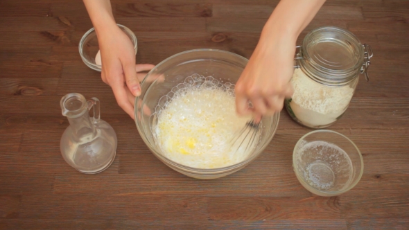 Woman Preparing a Muffins On The Kitchen Mixes Ingredients