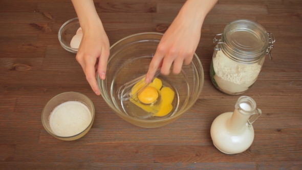 Woman Preparing a Muffins On The Kitchen Mixes Eggs