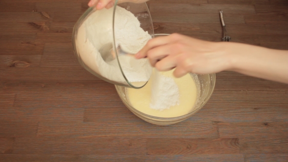 Woman Preparing a On The Kitchen Mixes Ingredients