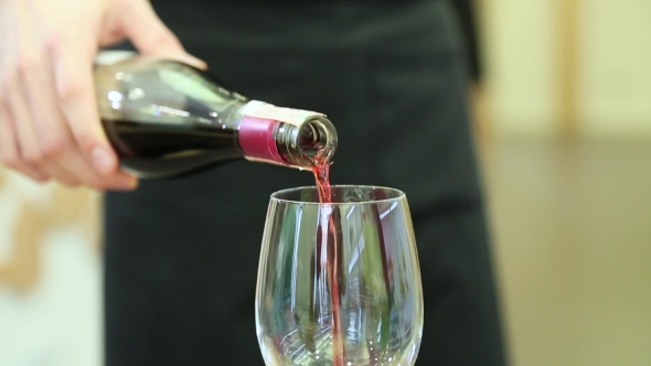 The Waiter Pours Wine Into a Glass