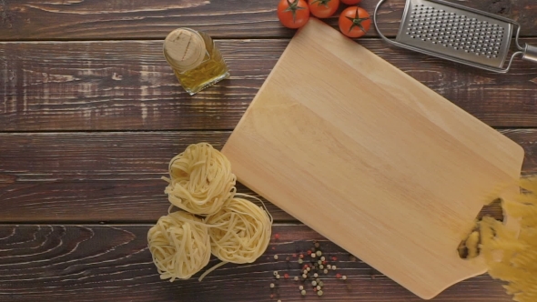 Pasta And Ingredients On Dark Wooden Background.