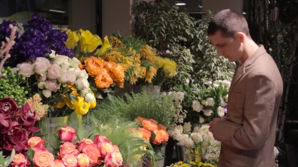 Man Chooses The Flowers For a Bouquet In Shop