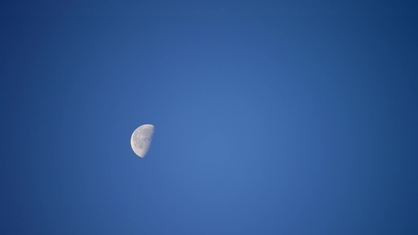 Moon Moves Across Cloudless Blue Sky