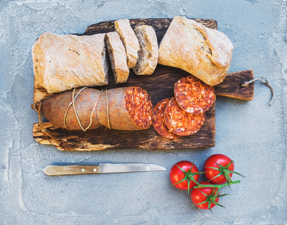 Wine snack set. Hungarian mangalica pork salami sausage, rustic bread and fresh tomatoes - Stock Photo - Images