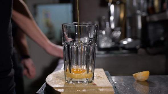 Bartender Is Making Cocktail. Bartender Adds Honey Syrup In a Glass alt