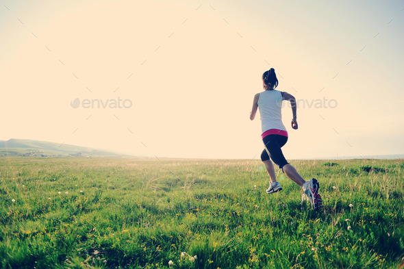 Runner athlete running on grass seaside - Stock Photo - Images