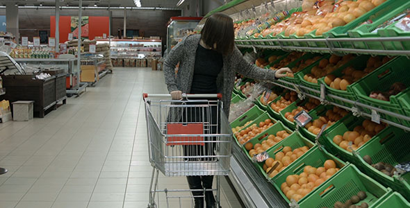 A Woman Buys Fruit at the Store