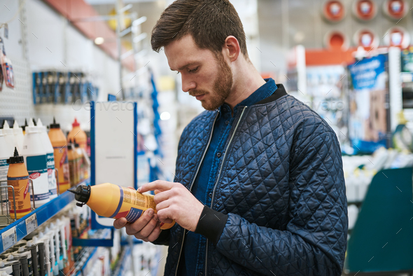 Man selecting a product in a hardware store - Stock Photo - Images