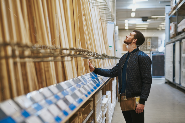 Carpenter selecting wood in a hardware store - Stock Photo - Images