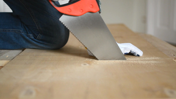 Man Sawing Pressed Wooden Board
