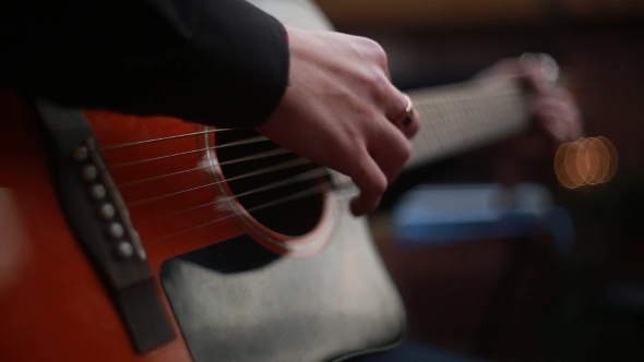 Man Playing On a 6-String Acoustic Guitar