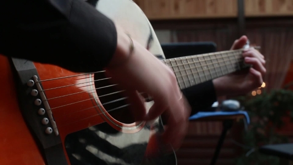 Man Playing On a 6-String Acoustic Guitar