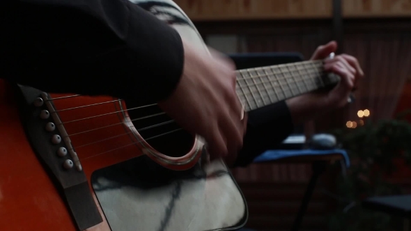Man Playing On a 6-String Acoustic Guitar