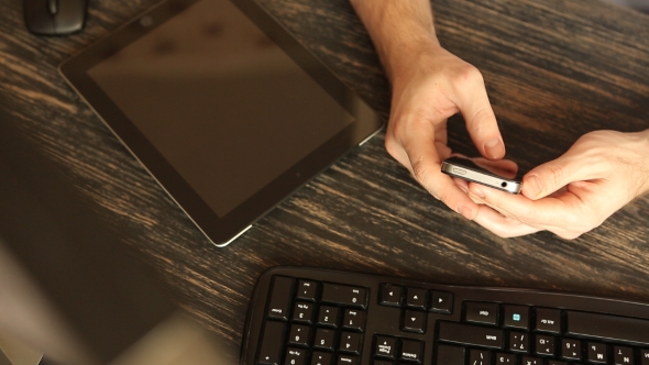 Hands With Mobile Phone At Wooden Desk alt