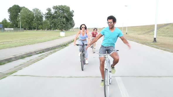 Three Young Adults Having Fun Cycling And Taking Selfies alt