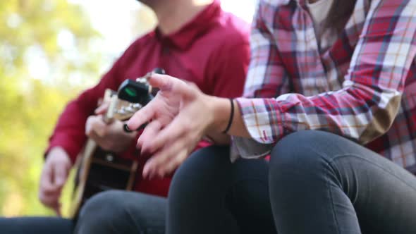 Man Playing Guitar While Beautiful Woman Singing alt