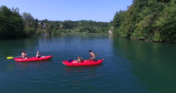 Four Young Friends Paddling Canoe And Splashing Each Other With Water 2 alt