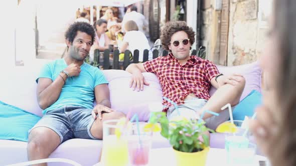 Two Male Friends Sitting On Terrace Cafe In Summer 1 alt