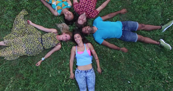 View From Above Of Friends Forming A Star Shape Lying In Grass 2 alt