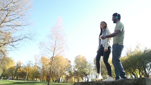 Couple Listening To Music On Headphones And Dancing At The Park 2 alt
