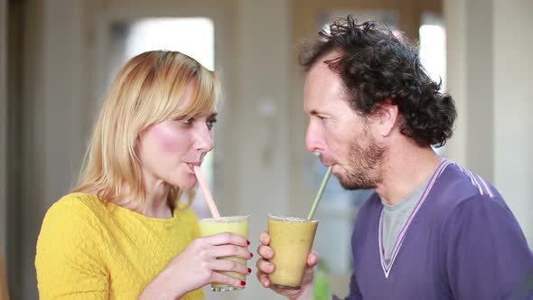 Happy Couple Toasting And Drinking Fruit Smoothie 1 alt