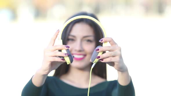 Beautiful Woman Putting On Headphones And Listening To Music alt