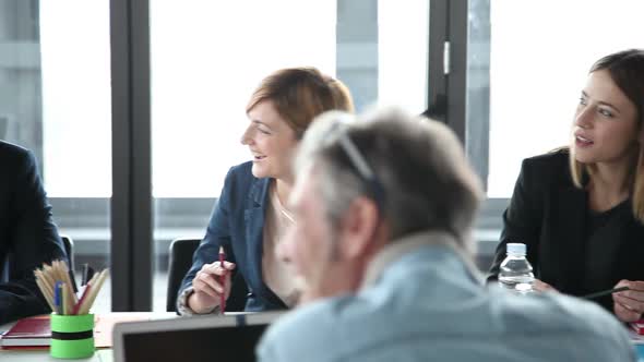 Smiling Business People Sitting At Table On A Meeting In Conference Room alt