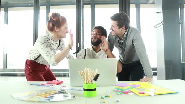 Male Creative Executive High-Fiving With Colleagues In Office 2 alt