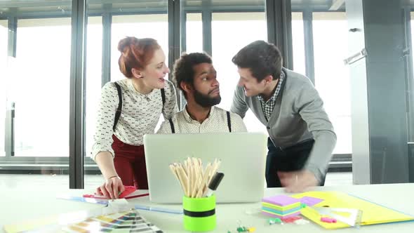 Male Creative Executive Shaking Hands With Colleagues In Office alt