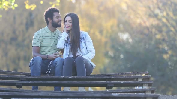 Man Kissing Woman On A Cheek While They Listening To Music On Earphones 3 alt