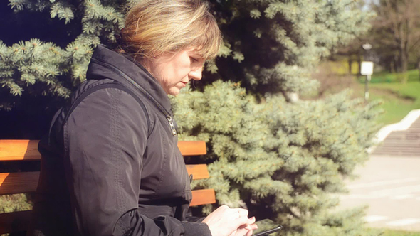 Woman in City Park With Tablet