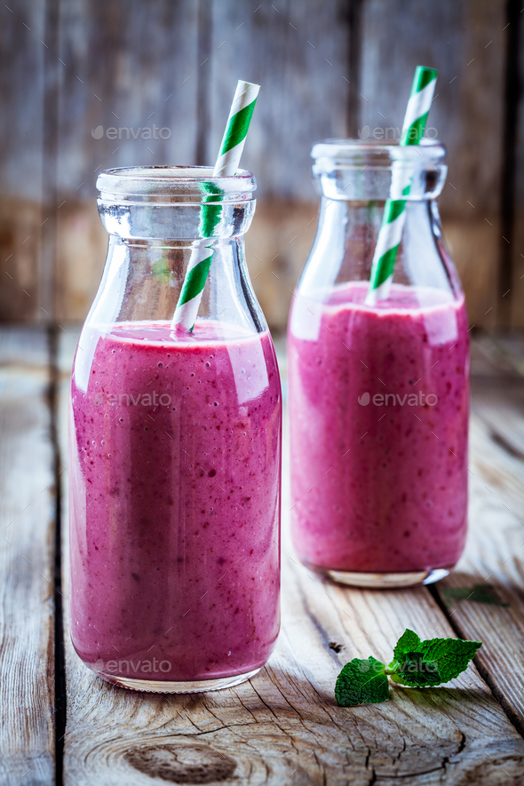 juicy blackberry smoothies in glass bottles Stock Photo by nblxer