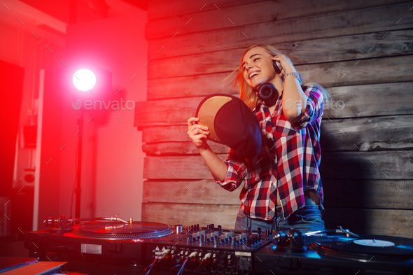 Cute dj woman having fun playing music at club party