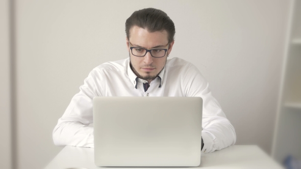 Handsome Young Man In Shirt Working On Laptop While Sitting At His Working Place alt
