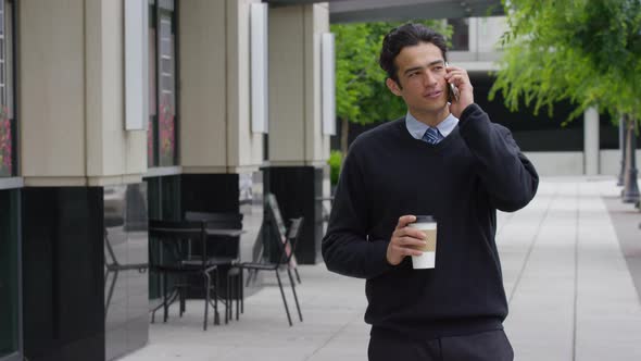 Young businessman talking on cell phone outdoors