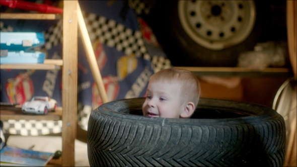 Boy Hiding In Pile Of Tyres, Stock Footage | VideoHive