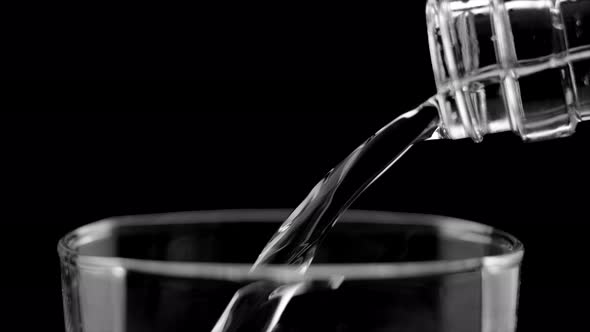 Pouring Still Water Into the Glass on the Black Background
