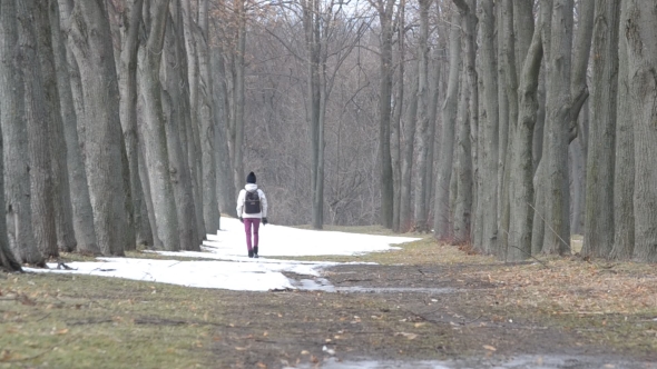 Teenager Girl With Backpack Walks In Winter In a Park