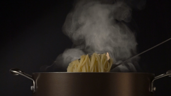 Steaming Pasta In a Spaghetti Spoon On Black Background