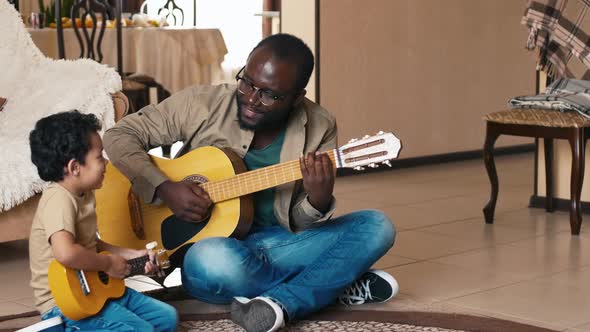 Father and son with guitars singing song at home