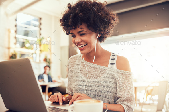 Happy woman at cafe using laptop - Stock Photo - Images