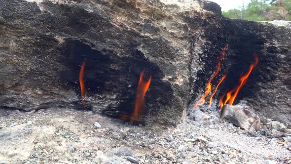 Flame of Methane Underground Emerges From Crack Between Rocks and Burns to Earth alt