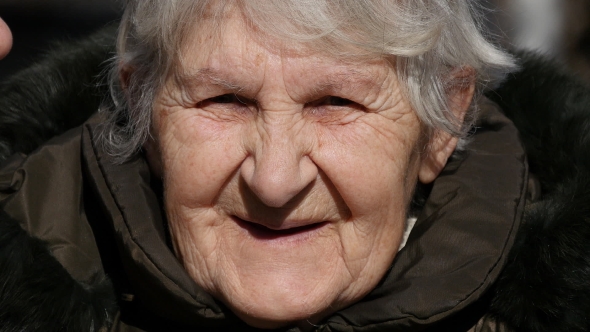 Young Girl And Adult Woman Kissing Grandmother On Cheeks alt