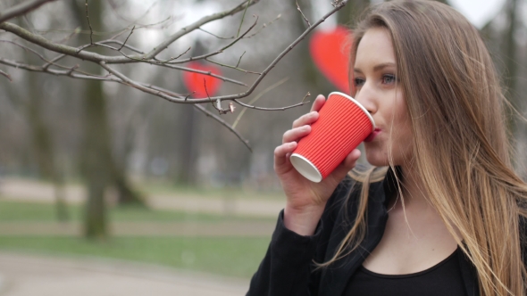 Portrait Of Beautiful Young Urban Fashion Girl In Autumn Park Drinking Cup Of Takeaway Coffee