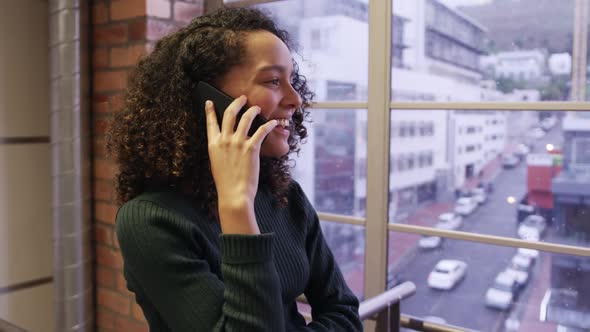 Creative businesswoman talking on smartphone in modern office alt