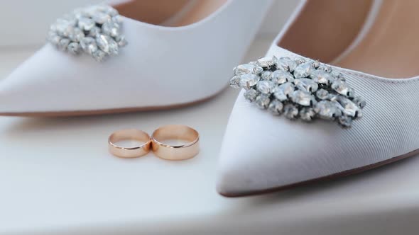 Wedding rings and bridal shoes. Pair of marriage symbols. Matrimony symbol alt