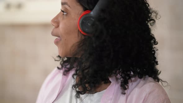Closeup Joyful Young Woman in Headphones Singing Dancing Cooking in the Morning at Home alt