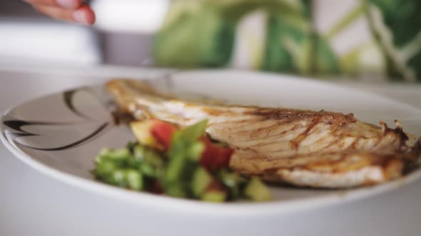 Close Up View of Hand Squeezing Lemon on Baked Sea Bass Fillet alt